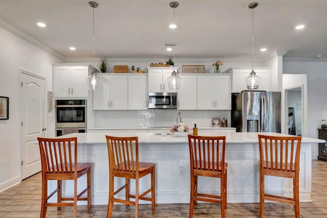 2707 162nd Ave E, Parrish, FL 34219 - kitchen with appliances with stainless steel finishes, a large island with sink, crown molding, light countertops, and backsplash