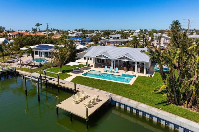 527 Key Royale Dr, Holmes Beach, FL 34217 - rear view of house featuring a yard, a water view, a patio, an outdoor pool, and a residential view