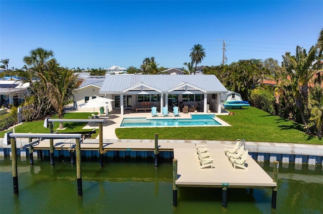 527 Key Royale Dr, Holmes Beach, FL 34217 - rear view of property featuring a patio, an outdoor pool, a water view, a yard, and fence