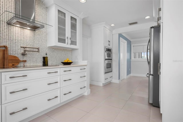 527 Key Royale Dr, Holmes Beach, FL 34217 - kitchen with appliances with stainless steel finishes, light tile patterned flooring, wall chimney range hood, and visible vents