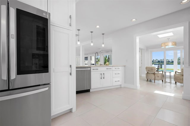 527 Key Royale Dr, Holmes Beach, FL 34217 - kitchen with light countertops, appliances with stainless steel finishes, white cabinetry, recessed lighting, and pendant lighting