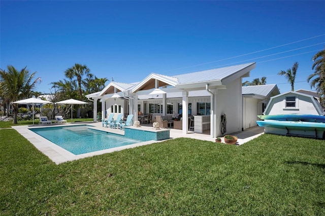 527 Key Royale Dr, Holmes Beach, FL 34217 - rear view of property with an outdoor pool, a patio, metal roof, and a lawn