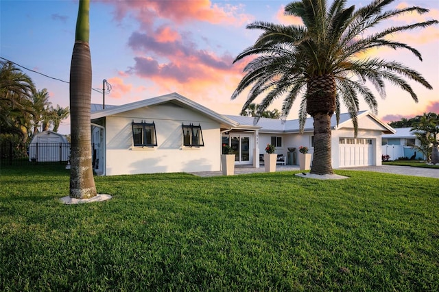 527 Key Royale Dr, Holmes Beach, FL 34217 - single story home featuring a garage, stucco siding, a lawn, fence, and driveway