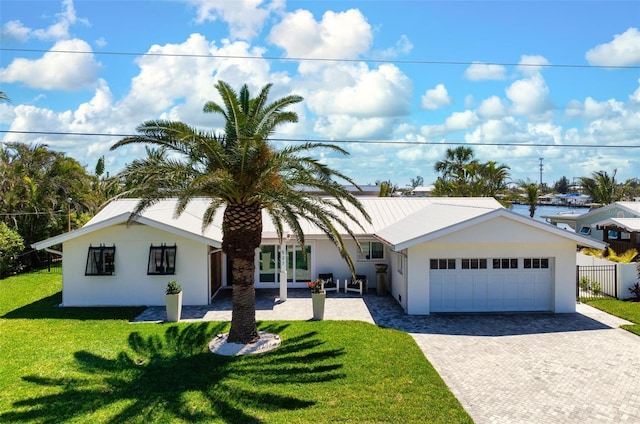 527 Key Royale Dr, Holmes Beach, FL 34217 - ranch-style home featuring an attached garage, fence, stucco siding, a front lawn, and driveway