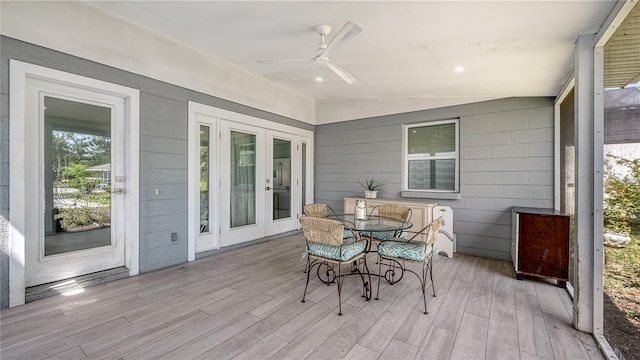 sunroom / solarium with a ceiling fan, outdoor dining space, and french doors