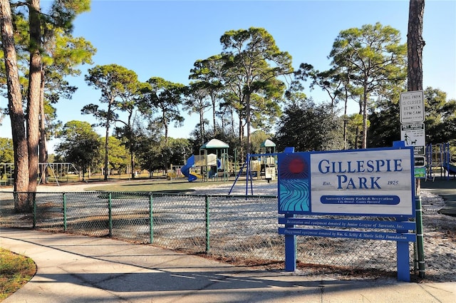 view of community featuring playground community and fence