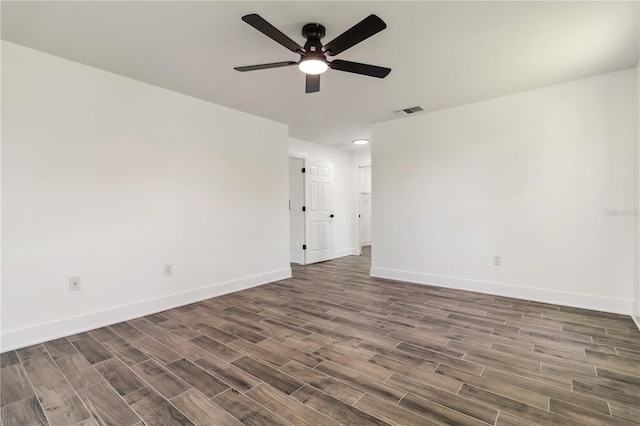 unfurnished room featuring a ceiling fan, baseboards, visible vents, and wood finished floors