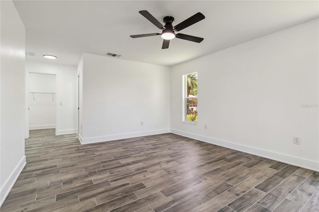 unfurnished room featuring baseboards, ceiling fan, visible vents, and wood finished floors