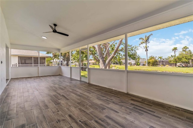 unfurnished sunroom with plenty of natural light, ceiling fan, and wood finished floors