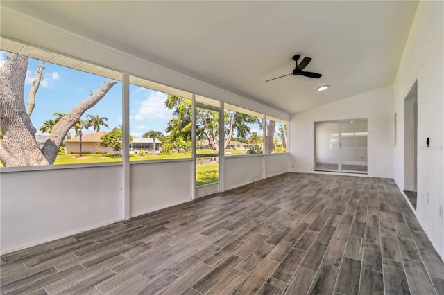 unfurnished sunroom with a ceiling fan, wood finished floors, and vaulted ceiling