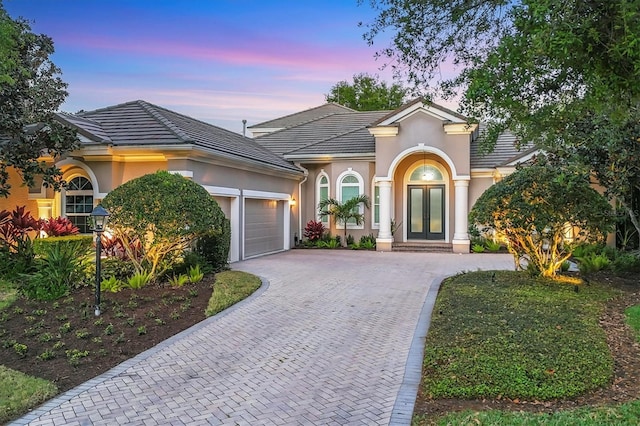 7257 Greystone St, Lakewood Ranch, FL 34202 - view of front of house featuring stucco siding, a garage, french doors, and decorative driveway