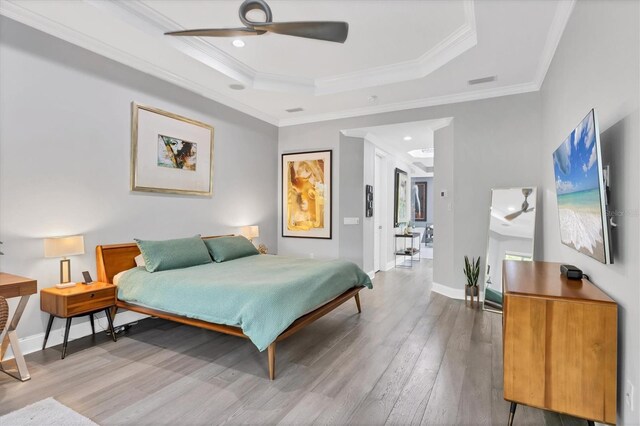 7257 Greystone St, Lakewood Ranch, FL 34202 - bedroom featuring baseboards, a tray ceiling, wood finished floors, and crown molding