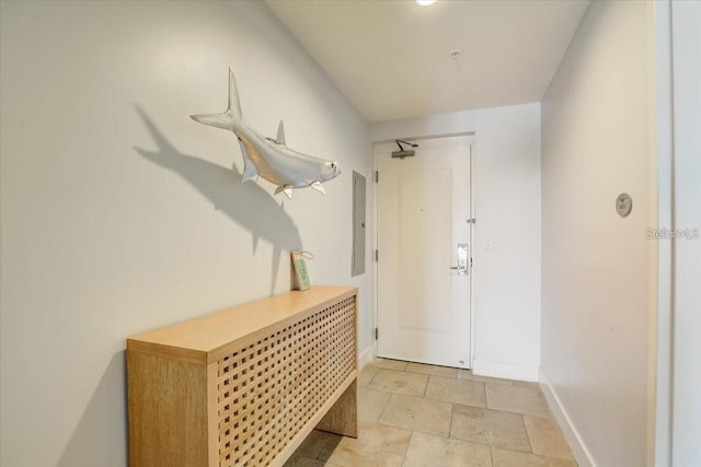 interior space featuring electric panel, baseboards, and stone tile flooring