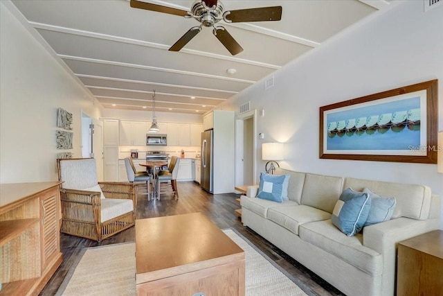 living room with dark wood-style floors, visible vents, a ceiling fan, and beam ceiling