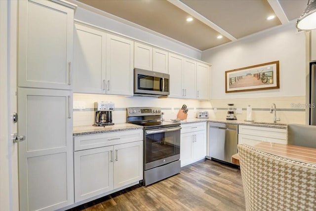 kitchen featuring a sink, backsplash, wood finished floors, appliances with stainless steel finishes, and recessed lighting