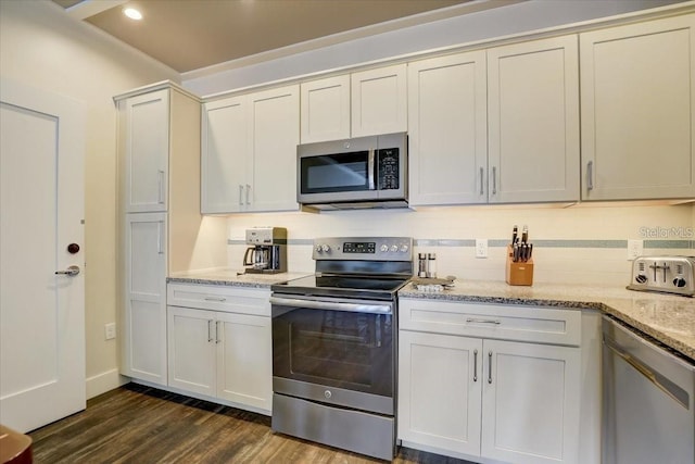 kitchen with recessed lighting, dark wood-type flooring, decorative backsplash, light stone countertops, and appliances with stainless steel finishes