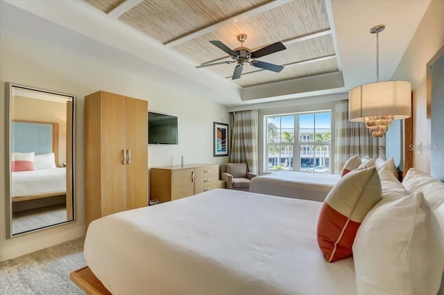bedroom with carpet flooring, a tray ceiling, ceiling fan, and wooden ceiling