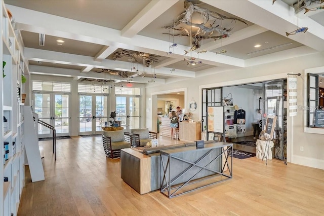 living area featuring baseboards, beam ceiling, light wood-style floors, french doors, and coffered ceiling