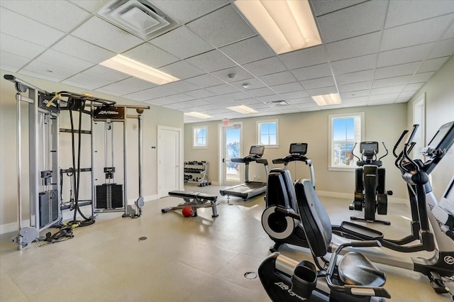 workout area featuring baseboards, visible vents, and a paneled ceiling
