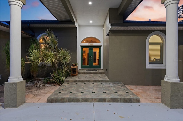 property entrance featuring stucco siding and french doors