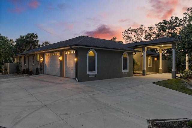 view of front of home with an attached garage, driveway, and stucco siding
