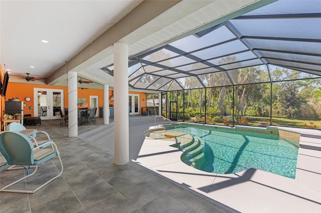 outdoor pool with a lanai, a ceiling fan, french doors, and a patio