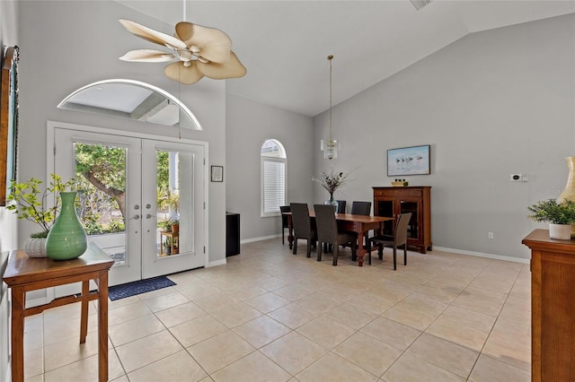 foyer entrance with high vaulted ceiling, light tile patterned flooring, and plenty of natural light