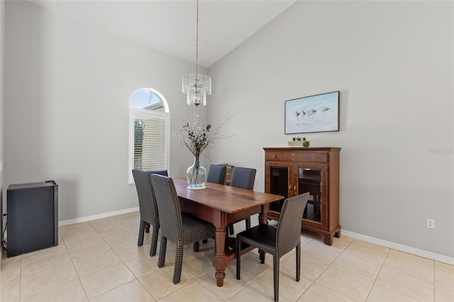 dining room featuring a chandelier, baseboards, high vaulted ceiling, and light tile patterned floors