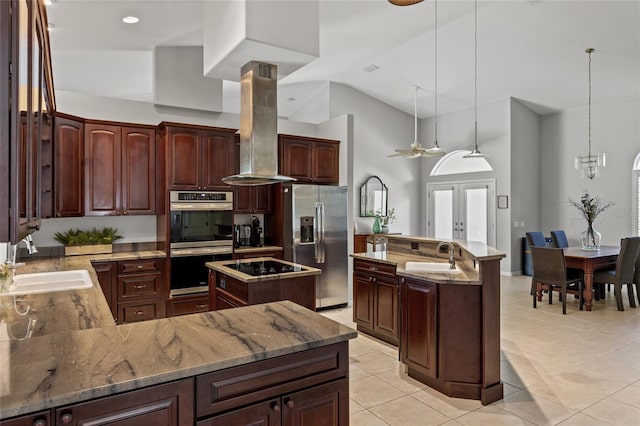 kitchen with island range hood, an island with sink, stainless steel appliances, and a sink