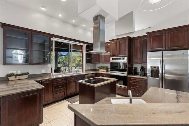 kitchen featuring island exhaust hood, a center island, stainless steel appliances, and a sink