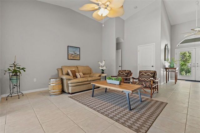 living room featuring arched walkways, baseboards, a ceiling fan, high vaulted ceiling, and light tile patterned floors