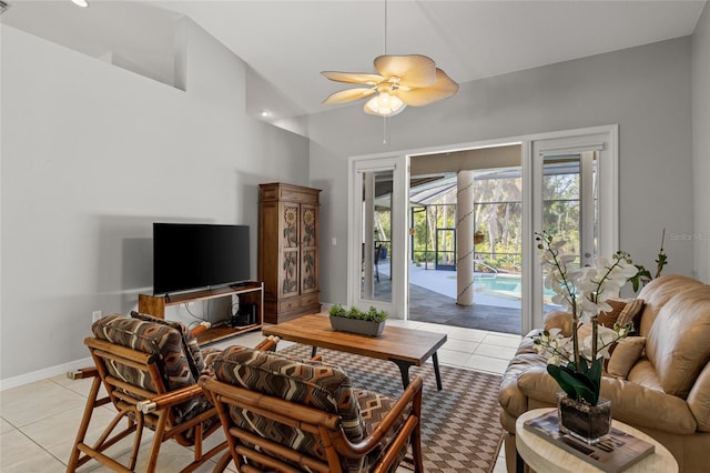 living room featuring lofted ceiling, ceiling fan, baseboards, and light tile patterned floors
