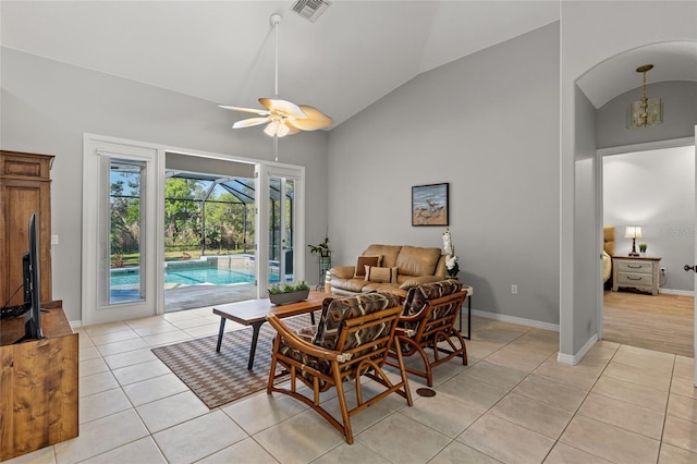 living room featuring visible vents, light tile patterned floors, baseboards, a sunroom, and ceiling fan