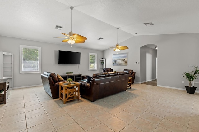living area with arched walkways, vaulted ceiling, visible vents, and a ceiling fan
