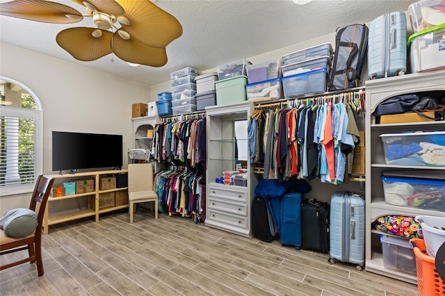 walk in closet with ceiling fan and wood finished floors