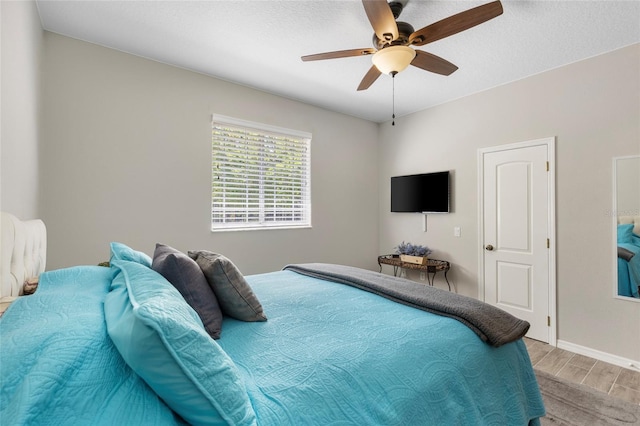 bedroom featuring ceiling fan, baseboards, and light wood-style flooring