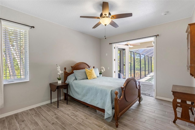 bedroom with access to outside, multiple windows, and light wood-type flooring