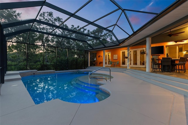 outdoor pool with a patio area, french doors, glass enclosure, and ceiling fan