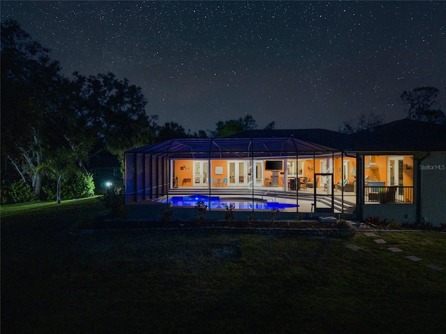 back of house at twilight featuring an outdoor pool, a patio, and french doors
