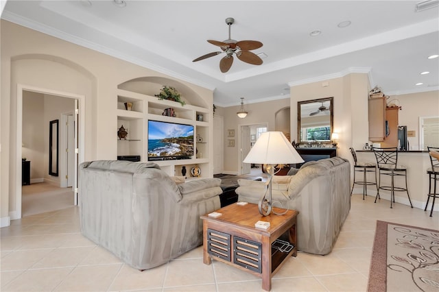 9818 Portside Ter, Bradenton, FL 34212 - living room featuring light tile patterned floors, crown molding, built in shelves, and ceiling fan