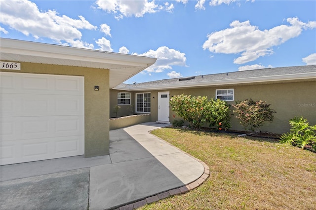 1665 Harmony Dr, Port Charlotte, FL 33952 - property entrance featuring stucco siding, a garage, and a lawn