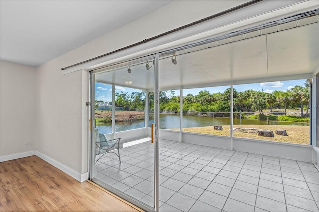 1665 Harmony Dr, Port Charlotte, FL 33952 - unfurnished sunroom with baseboards, a water view, and tile patterned floors