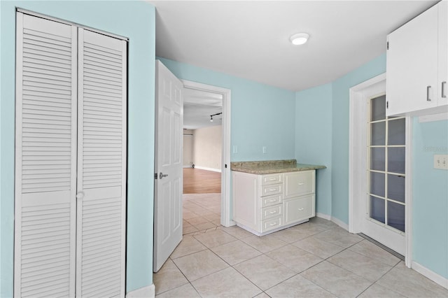 1665 Harmony Dr, Port Charlotte, FL 33952 - kitchen featuring light tile patterned flooring, baseboards, white cabinets, and light countertops