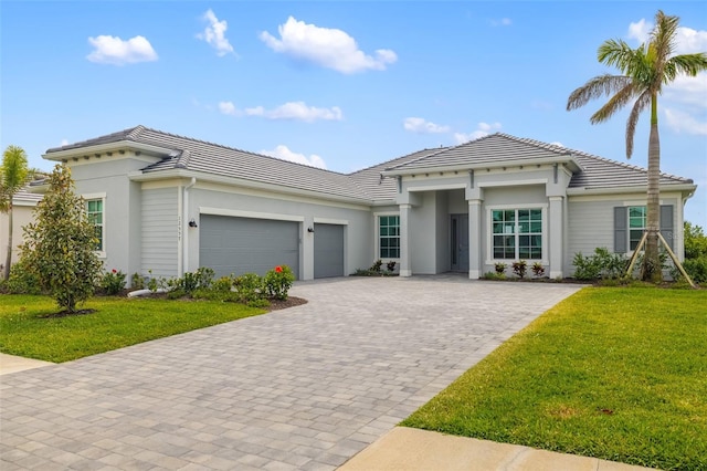 12557 Galapagos Ct, Venice, FL 34293 - view of front of house featuring a tiled roof, decorative driveway, a garage, and stucco siding