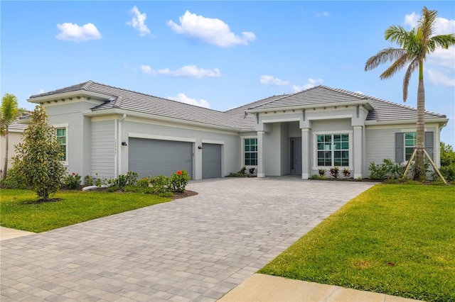 12557 Galapagos Ct, Venice, FL 34293 - view of front of house featuring a tile roof, an attached garage, decorative driveway, and a front lawn