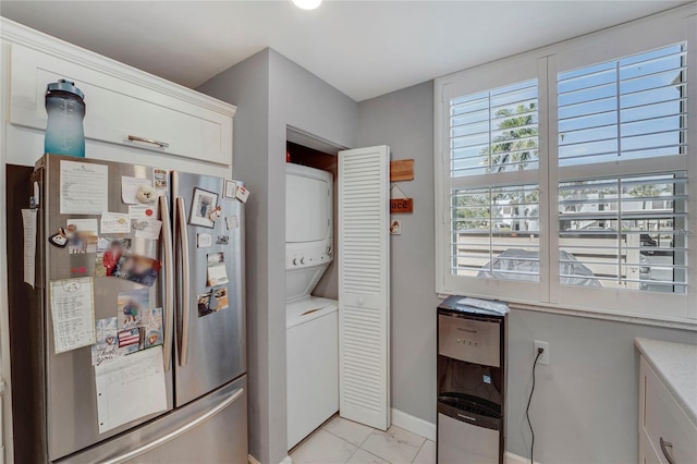 501 Lakeside Dr Unit 501, Bradenton, FL 34210 - kitchen with freestanding refrigerator, stacked washer and clothes dryer, white cabinetry, and baseboards