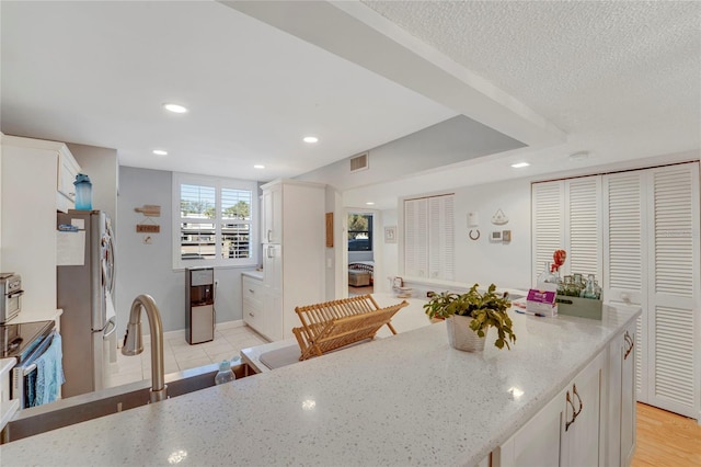501 Lakeside Dr Unit 501, Bradenton, FL 34210 - kitchen with white cabinetry, recessed lighting, light stone counters, visible vents, and appliances with stainless steel finishes