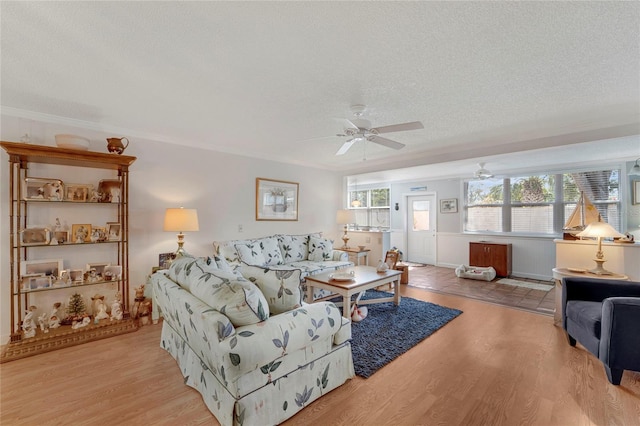501 Lakeside Dr Unit 501, Bradenton, FL 34210 - living area featuring light wood-style flooring, ornamental molding, ceiling fan, and a textured ceiling