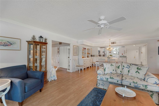 501 Lakeside Dr Unit 501, Bradenton, FL 34210 - living area featuring a textured ceiling, visible vents, light wood finished floors, ornamental molding, and ceiling fan with notable chandelier