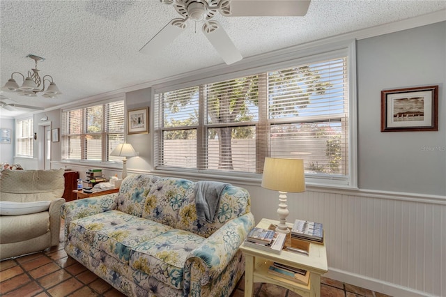 501 Lakeside Dr Unit 501, Bradenton, FL 34210 - living room featuring a textured ceiling, a wainscoted wall, and ceiling fan